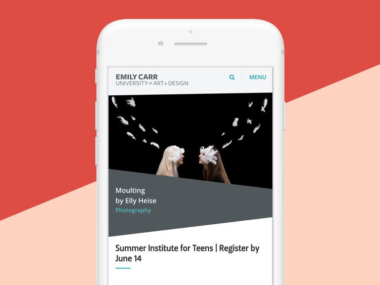 White mobile phone showing Emily Carr homepage over a pink angled background