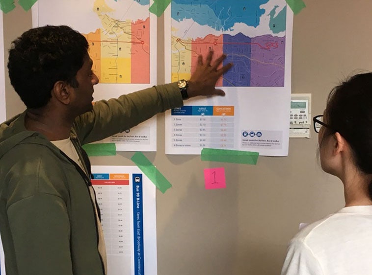 Photo of two people reviewing a document on a white board