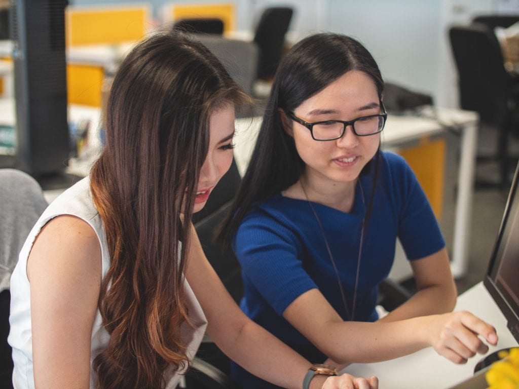 Photo showing two women working on a replatforming project