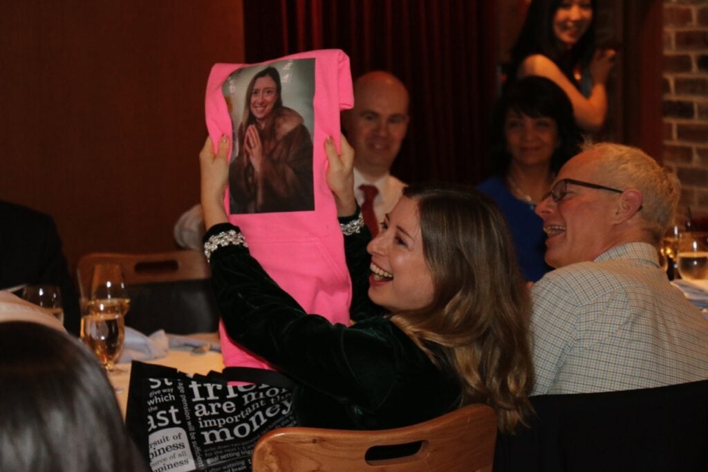 OXD staff Sara holding up a picture of her on a pink t-shirt