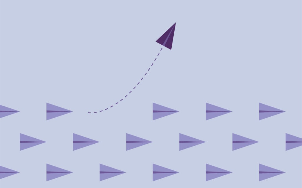 paper planes with one breaking away in shades of purple