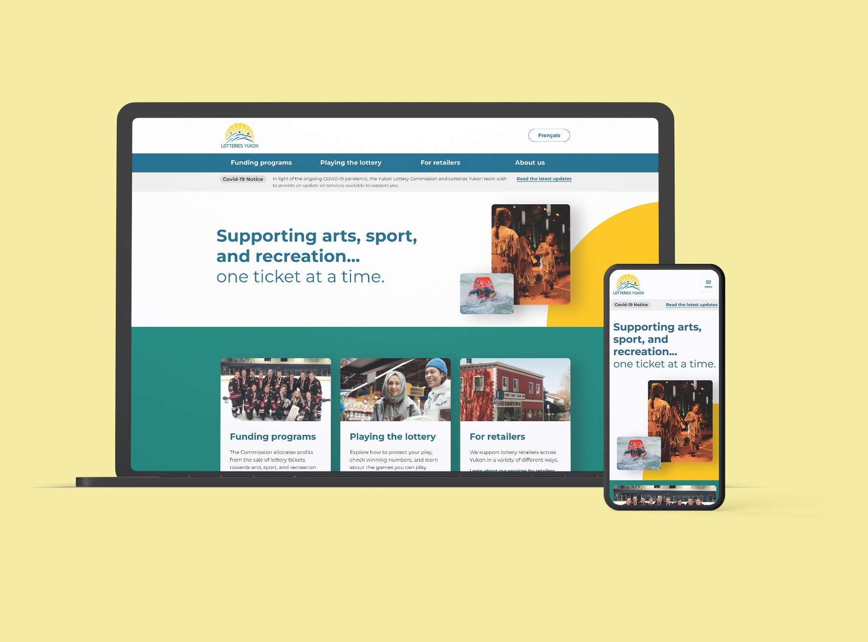 Lotteries Yukon home page on a black laptop and iphone clay on yellow background
