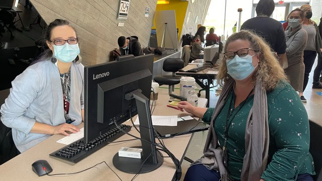Photo of Deborah MacKenzie, OXD (left) and Melanie Worobec, PHSA right, at the first pilot COVID-19 vaccination clinic in Vancouver, March 2021, which was successful due to service mapping methods.