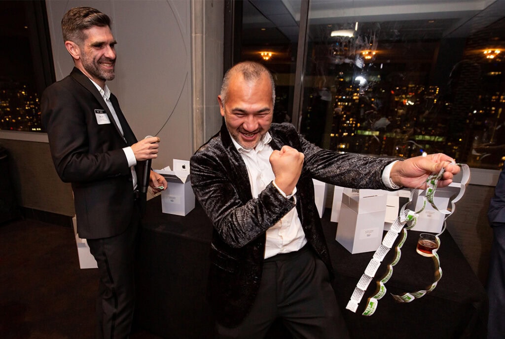 Photo of Lawrence winning the raffle prize and Gord laughing in the background