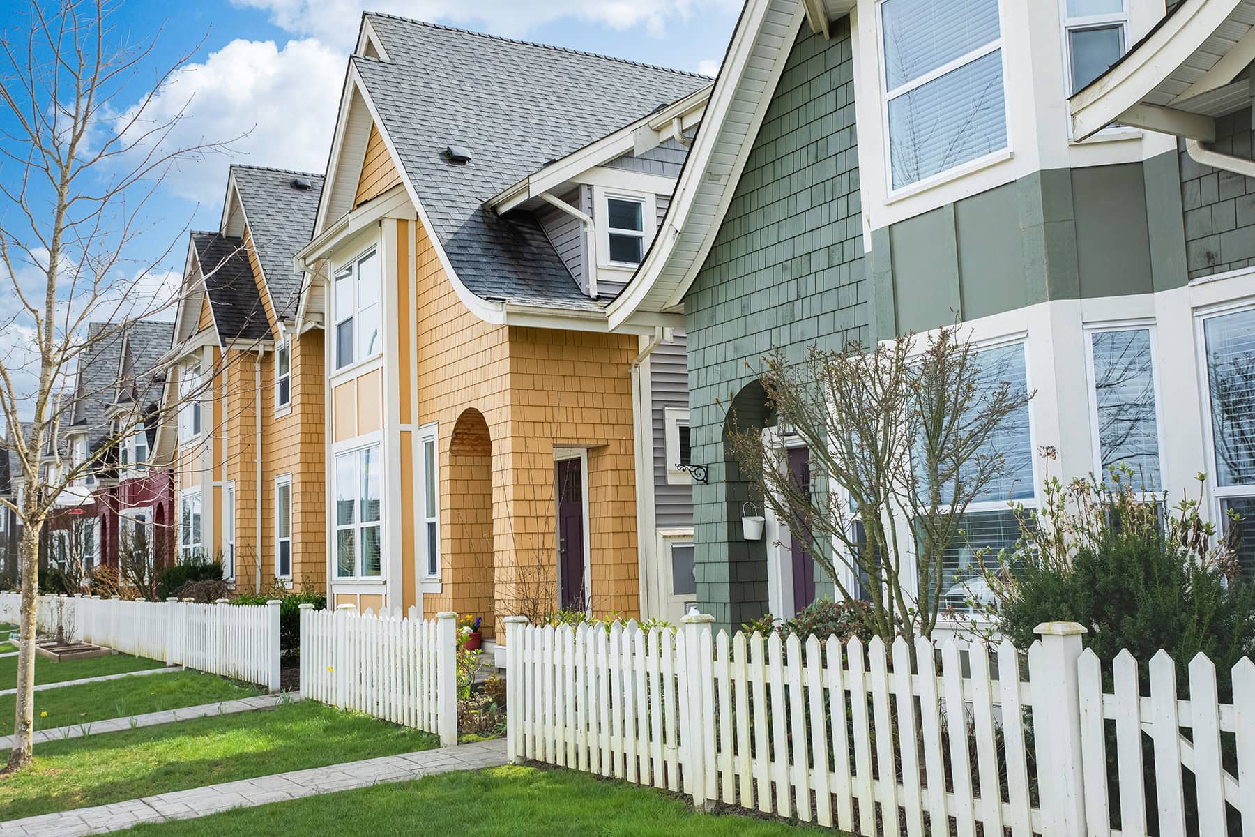 A row of colourful houses with a white fence lining the street in British Columbia